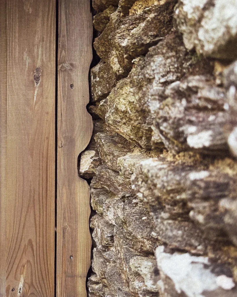 Détail d’un claustra en bois naturel et jonction avec la pierre – projet local en Pays Bigouden